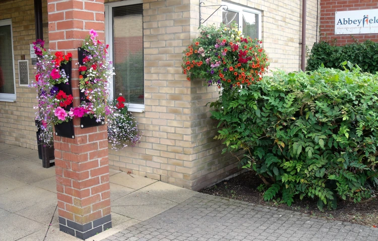 Front entrance of Paddy Geere House adorned with flowers and hanging baskets