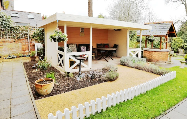 A sheltered outdoor seating area next to a wishing well in the garden where residents can enjoy the fresh air at Maitland House