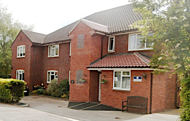 The front of the house with a bench under the window