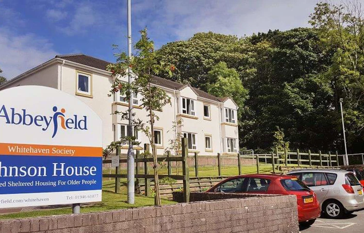 A large white house with a sign to the front