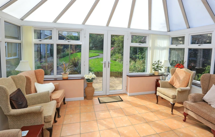 Bright conservatory with ample seating and views of the garden