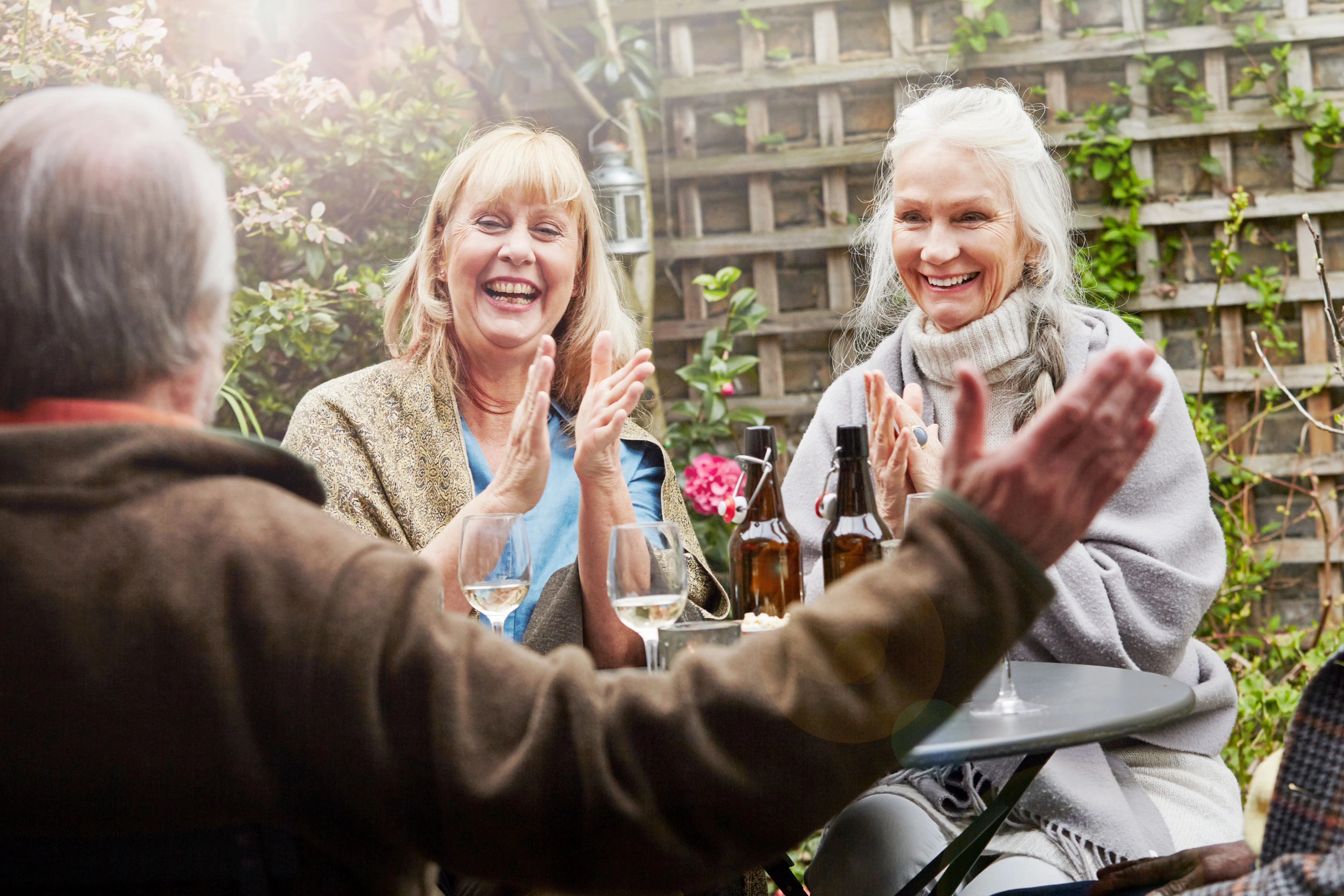 Happy older people laughing together outside in garden