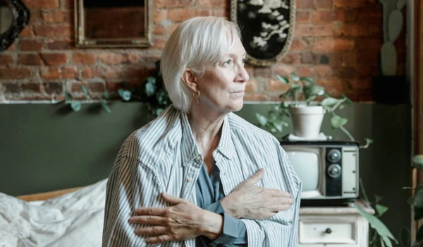 Older Woman Wrapped In Large Shirt Looking In The Distance