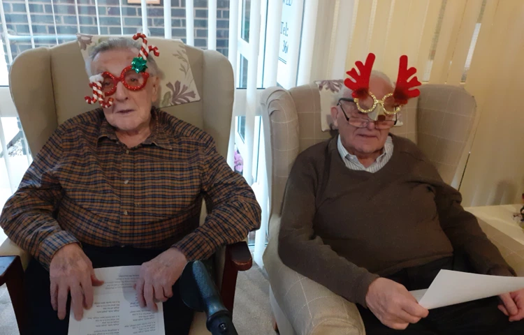 Residents Dressed In Festive Glasses Sitting Together