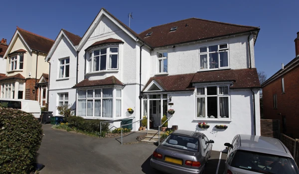 Front exterior of Abbeyfield House in Purley with parking spaces in front of house