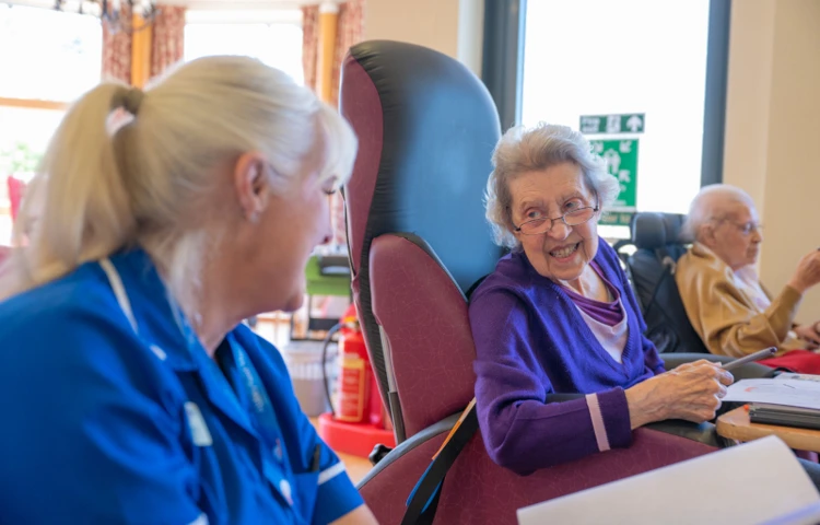 smiling-resident-and-staff-member-enjoying-an-activity-session.jpg