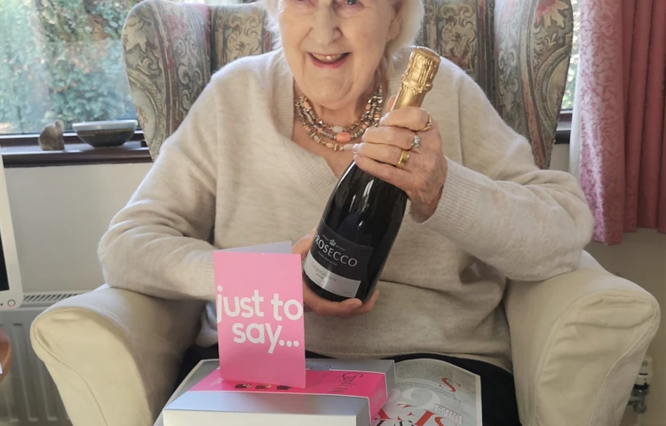 resident-holding-a-bottle-of-champagne-after-winning-competition.jpg