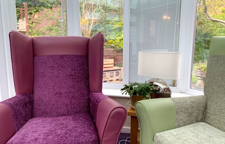 Comfortable armchairs in the conservatory overlooking the garden at Garrad House