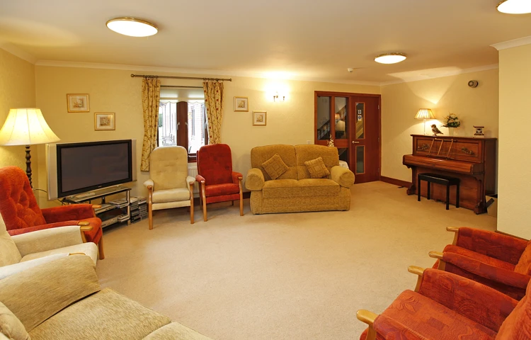 Bright room with seating, a TV and piano