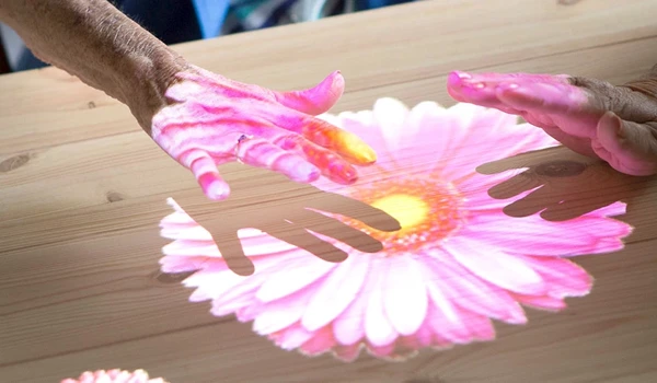 Tovertafel table with flower game which older people are enjoying playing