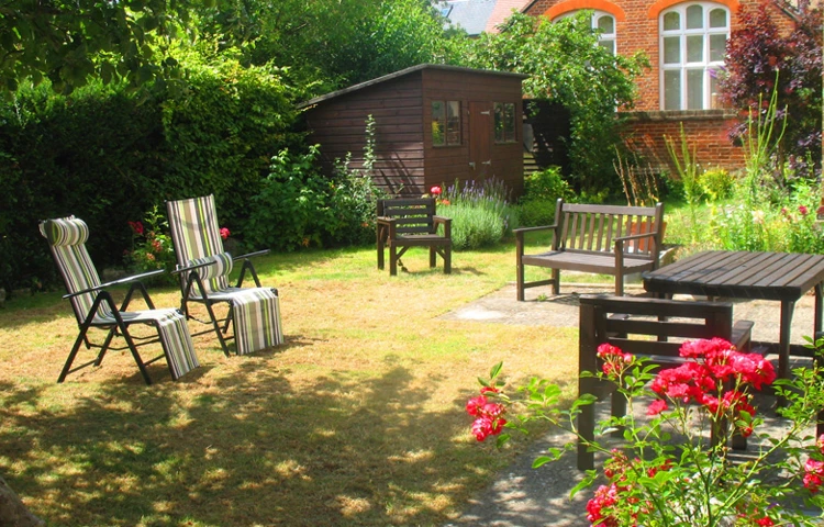 Sunny garden with tables and chairs where residents can enjoy the sunshine and a breath of fresh air